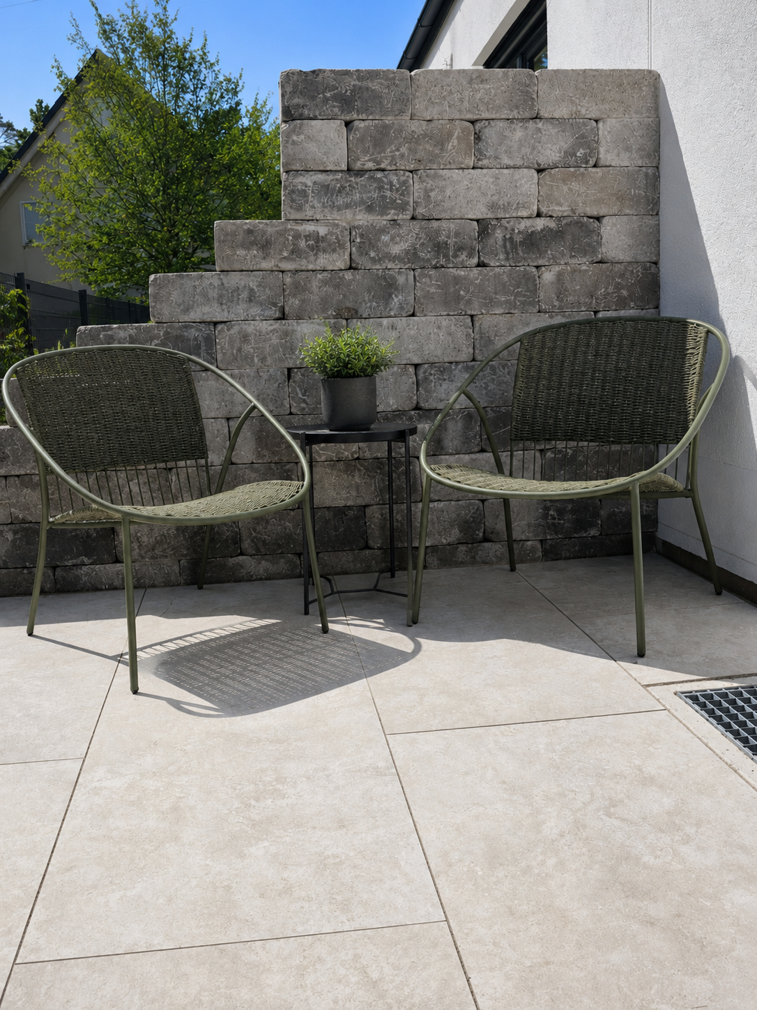 Hochwertige Terrasse mit Sitzplatz und bepflanzter Steinmauer