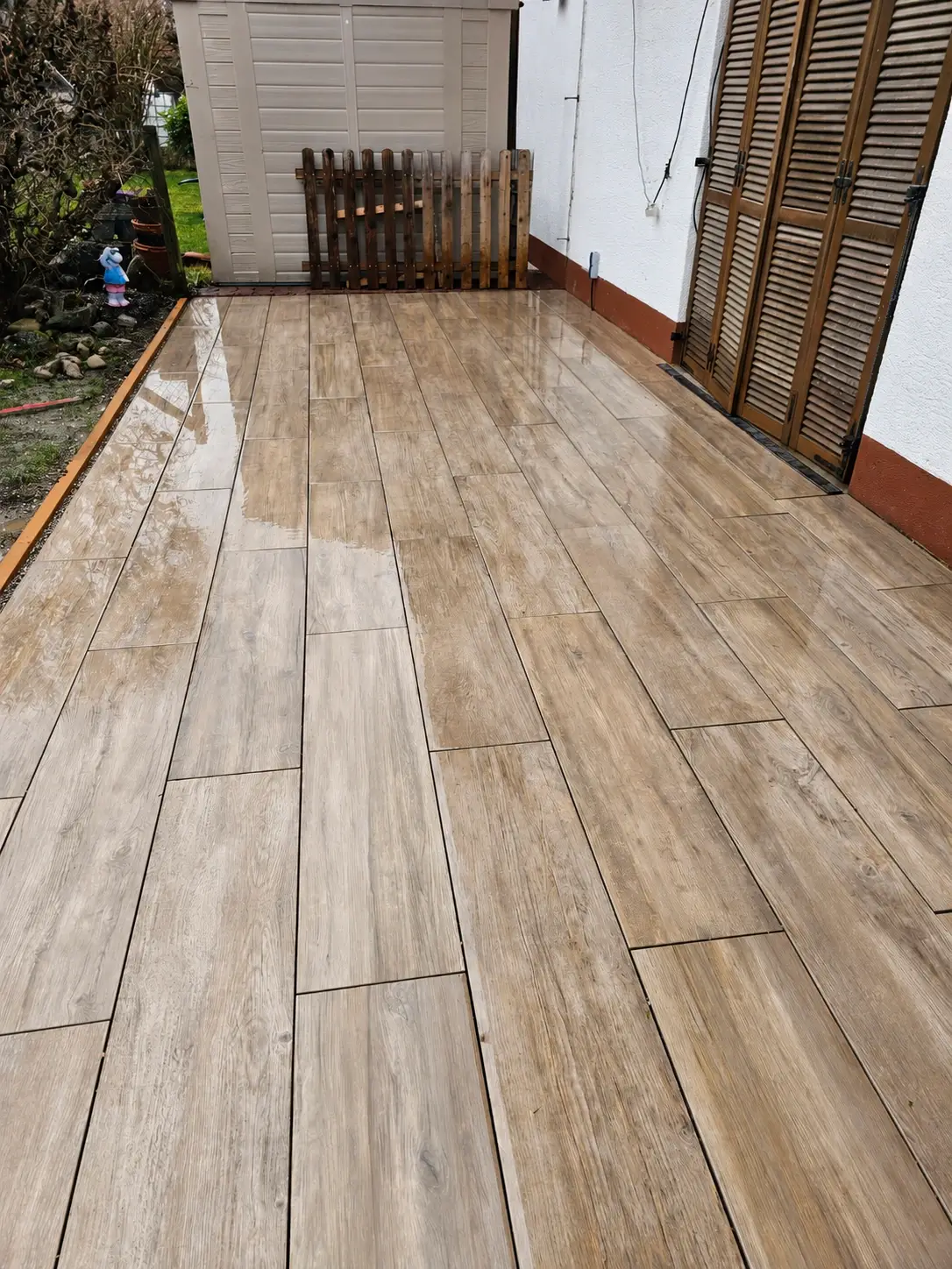 Terrassenplatten in Holzoptik vor den Holzfensterläden des Hauses in Landsberg