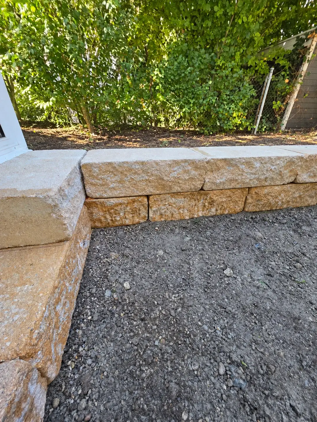 Detail der Einfassung aus Mauersteinen während des Sandkastenbaus