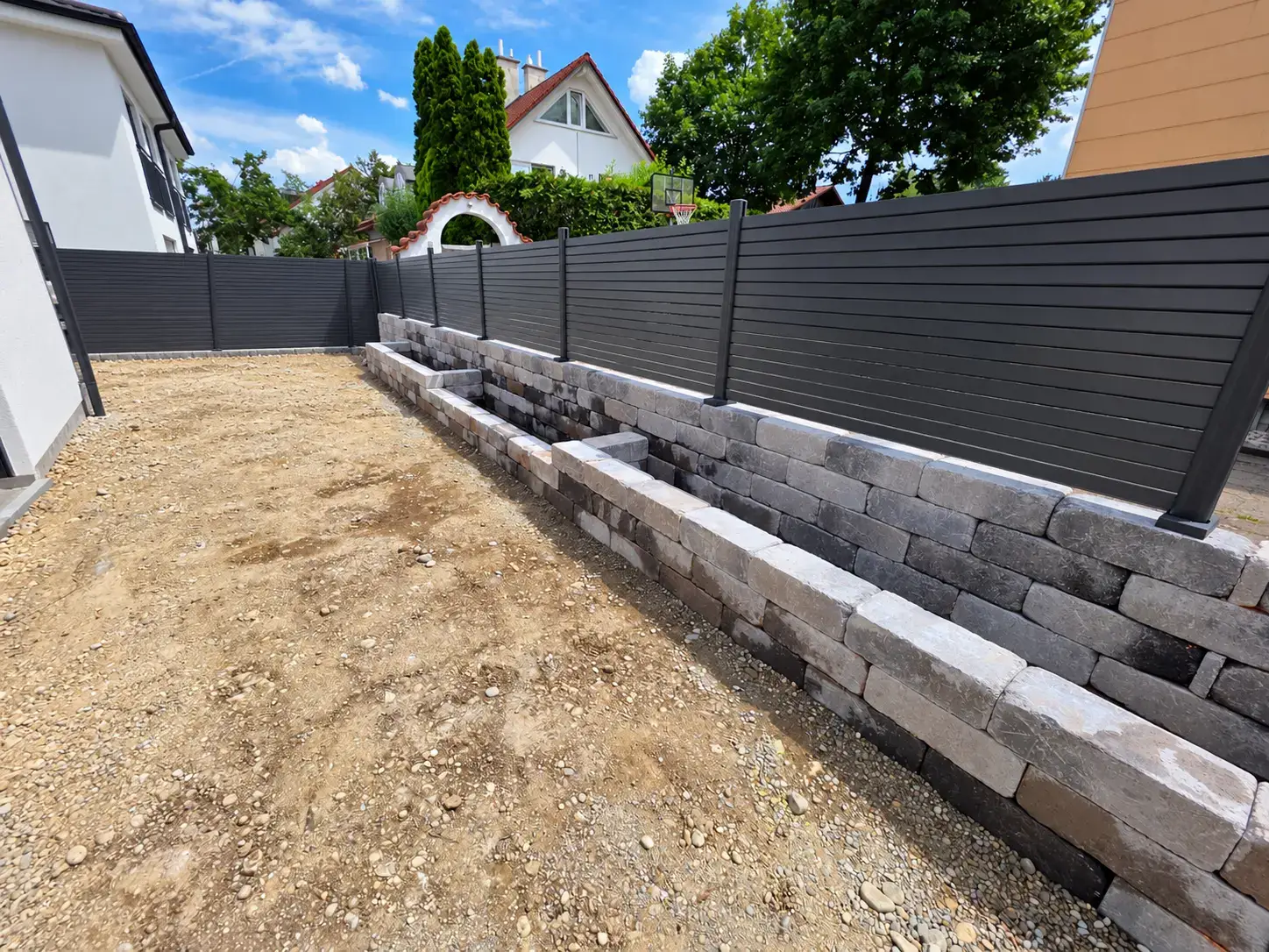 Bauphase der Gartenumgestaltung mit neu errichteten Pflanzmauern und noch unbepflanzter Fläche